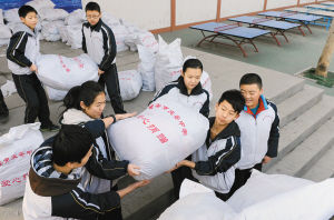 庆安中学学生将收集的旧衣服装车,送往山区给需要的孩子