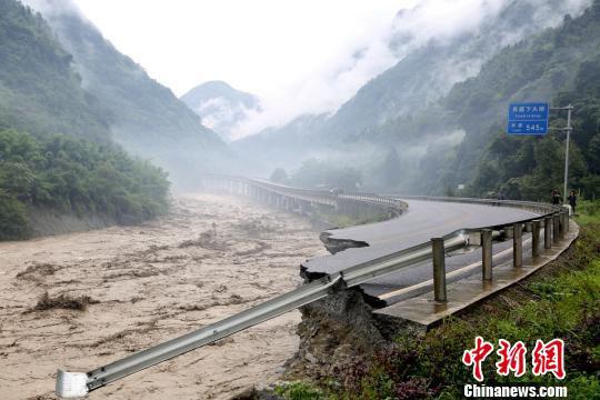 暴雨引发山洪冲毁道路。 桑锦 摄